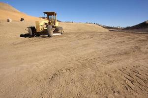 tracteur sur un chantier de construction et un terrain en terre. photo