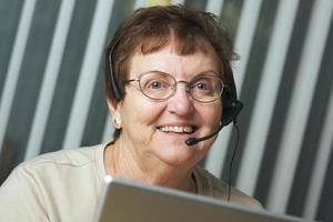 Senior senior souriant avec casque téléphonique photo