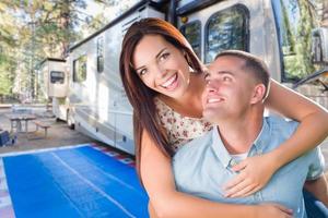 jeune couple militaire adulte devant leur magnifique camping-car au camping. photo