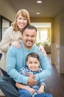 portrait de famille métisse à l'intérieur de leur nouvelle maison. photo