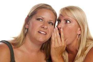 deux femmes blondes chuchotant des secrets