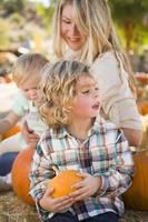 jeune famille profite d'une journée au champ de citrouilles photo