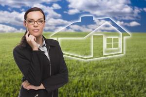 femme et champ d'herbe avec une maison fantôme derrière photo