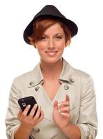 souriante jeune femme tenant un téléphone portable intelligent sur blanc photo