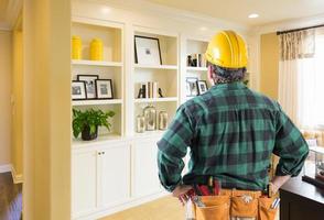 entrepreneur faisant face à un mur d'étagères et d'armoires intégrés sur mesure photo