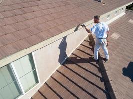 peintre professionnel utilisant un pinceau pour peindre le fascia de la maison photo