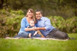 heureuse famille métisse ayant un pique-nique et jouant dans le parc photo