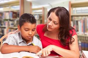 jeune garçon hispanique et famille adulte étudiant à la bibliothèque photo