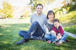 Happy mixed race family s'amusant dehors sur l'herbe photo