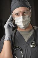 femme médecin ou infirmière portant des gommages, un masque protecteur et des lunettes photo