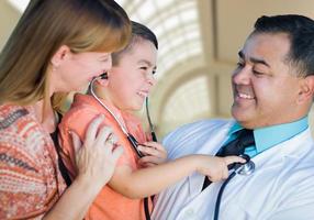 garçon de race mixte, mère et médecin s'amusant avec un stéthoscope photo