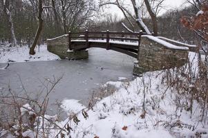 beau pont en bois sur un ruisseau gelé photo