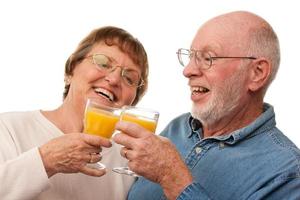 heureux couple de personnes âgées avec des verres de jus d'orange photo