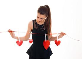 jolie jeune femme aux lèvres rouges célébrant la Saint Valentin avec des coeurs isolés sur fond blanc photo