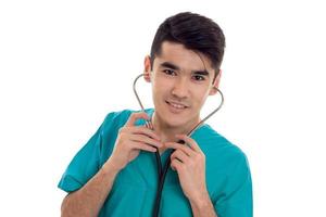 Beau jeune homme médecin en uniforme avec stathoscope posant isolé sur fond blanc photo