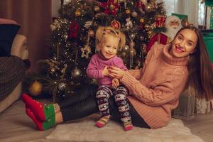 jolie mère et fille à l'arbre de noël photo