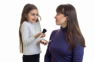 petite fille souriante peint sa mère blush est isolé sur fond blanc photo