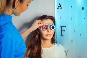 une femme adulte vérifie la vision d'un ophtalmologiste avec des verres correcteurs photo