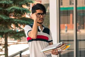 portrait d'un étudiant glamour mignon dans des verres avec des livres photo