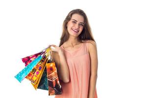 belle fille souriante tient dans ses sacs à main isolé sur fond blanc photo