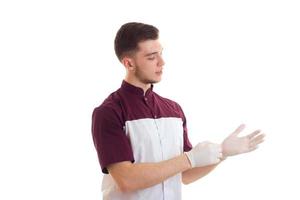 un jeune assistant de laboratoire met les mains sur des gants blancs en gros plan