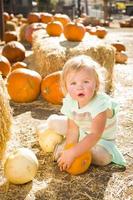 adorable petite fille tenant une citrouille au champ de citrouilles photo