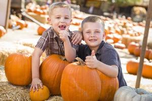 deux garçons au champ de citrouilles avec le pouce levé photo