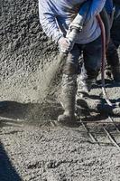 ouvrier en construction de piscine tirant sur du béton, du béton projeté ou de la gunite à travers un tuyau photo