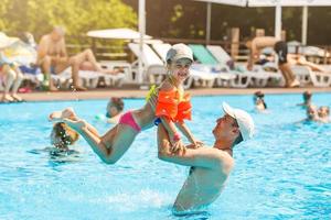 petite fille et père heureux s'amusant dans la piscine extérieure photo