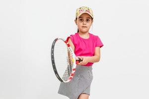 jolie petite fille avec une raquette de tennis sur fond blanc. photo