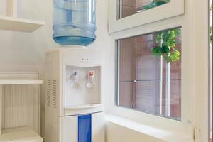 gallon d'eau bleue sur le refroidisseur d'eau électrique dans le coin bureau photo
