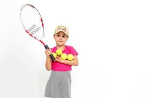 jolie petite fille avec une raquette de tennis dans ses mains sur fond blanc photo