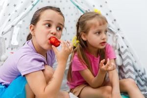 deux petites filles mangeant des fraises photo