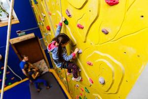 petite fille escaladant un mur de pierre photo