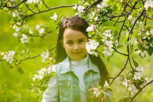 belle fille dans les pommiers en fleurs. cheveux longs photo