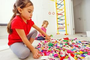 enfants heureux jouant avec des blocs à la maison ou à la garderie. jouer au jeu de concepteur de construction d'un gratte-ciel. jeu architectural comme jouet éducatif pour le préscolaire et le jardin d'enfants. photo