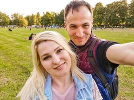 heureux jeune couple étreignant. homme et femme faisant des selfies isolés sur fond vert photo