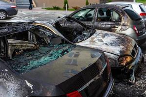 voiture brûlée. mettre le feu aux voitures sur le parking. guerres de bandits, la destruction de la machine à feu après le cocktail molotov. machine à feu déformée. conséquences d'un accident de voiture. endommagé par un incendie criminel photo