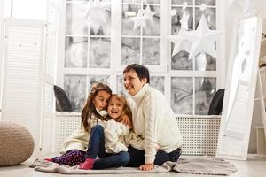 une mère heureuse embrasse ses deux filles à noël. photo