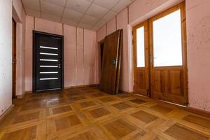 nouvelles portes dans une vieille maison, vieux plancher en bois à l'intérieur du salon vide photo