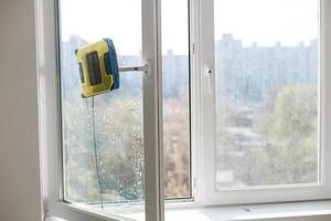 détail d'un robot de nettoyage de vitres agissant derrière une fenêtre photo
