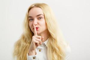 jolie souriante joyeusement femme aux cheveux blonds, habillée avec désinvolture, regardant avec satisfaction la caméra, étant heureuse. prise de vue en studio d'une belle belle femme isolée contre un mur de studio vierge photo