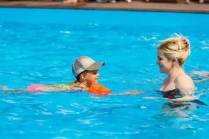 heureuse petite fille et mère dans la piscine photo