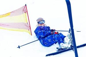 portrait d'une jolie skieuse en salopette bleue dans une station de ski photo