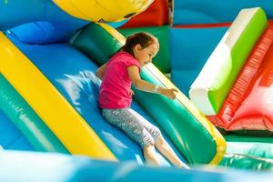 petite fille glissant sur un toboggan gonflable photo