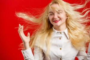 portrait d'une belle fille joyeuse avec des cheveux bouclés volants souriant en riant regardant la caméra sur fond photo