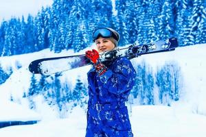 portrait d'une jolie skieuse en salopette bleue dans une station de ski photo