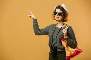 femme touristique voyageuse en vêtements décontractés d'été, chapeau avec valise isolée sur fond orange jaune. passagère voyageant à l'étranger pour voyager le week-end. concept de voyage en avion photo