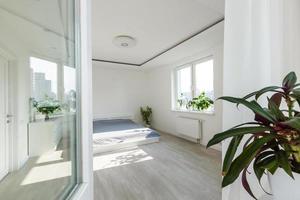 chambre blanche avec éléments en briques, balcon, lit double, bureau photo