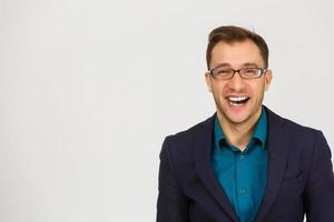 beau jeune homme sur un mur gris grunge avec un visage heureux debout et souriant avec un sourire confiant montrant les dents photo